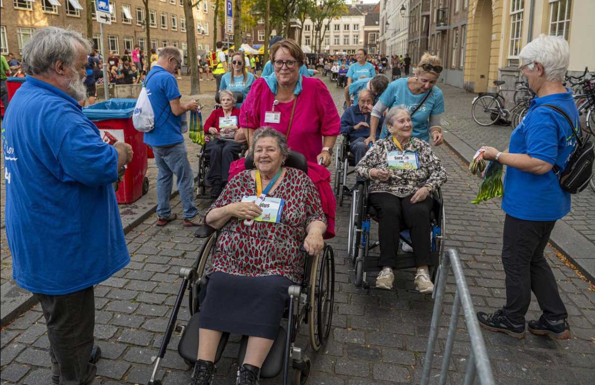 Ouderen in een rolstoel die onder begeleidingmeedoen